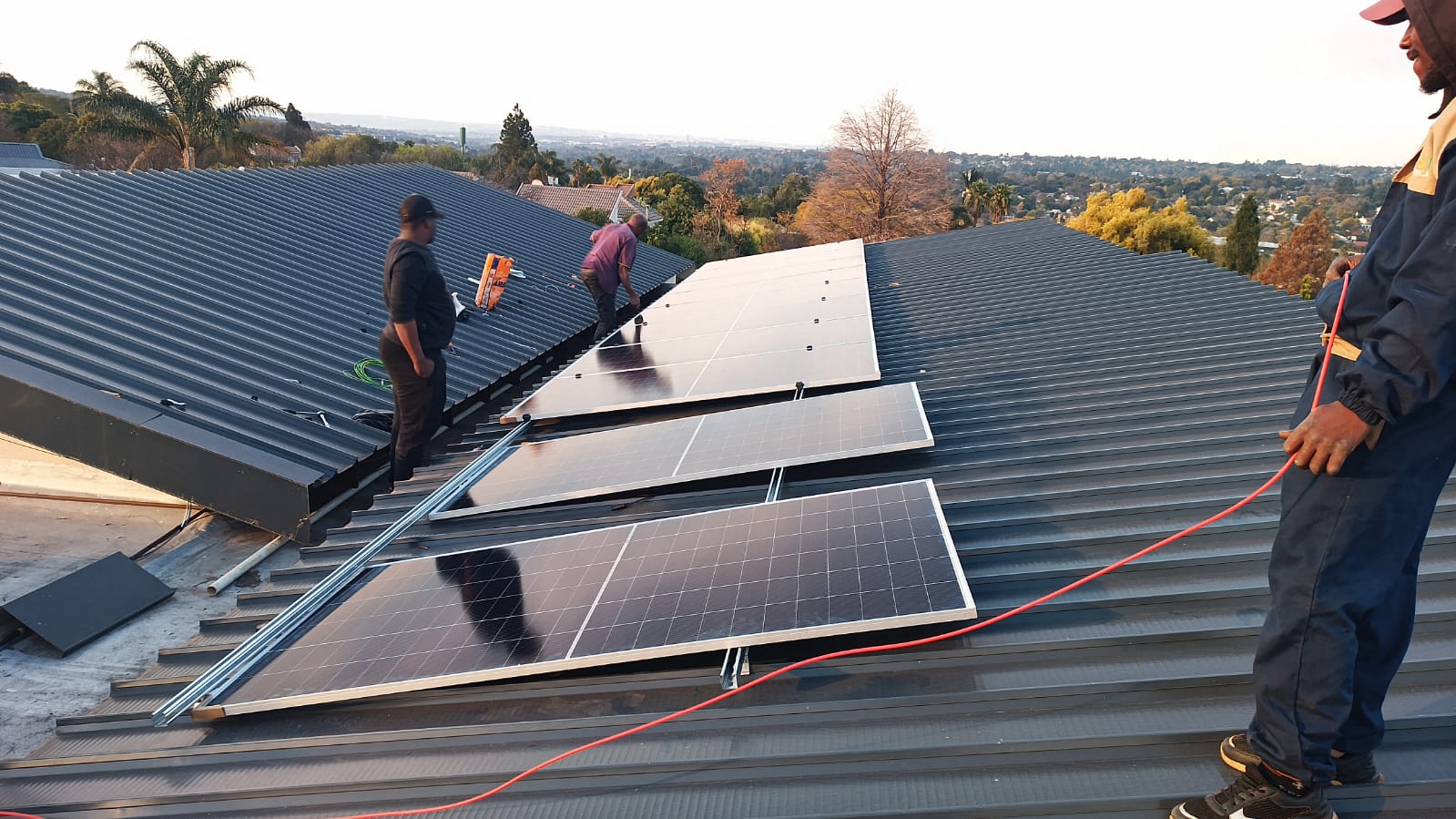 MVM Power Solutions team installing solar PV panels on a corrugated roof